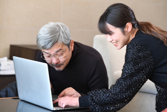 老人がパソコン操作を教えてもらっている様子