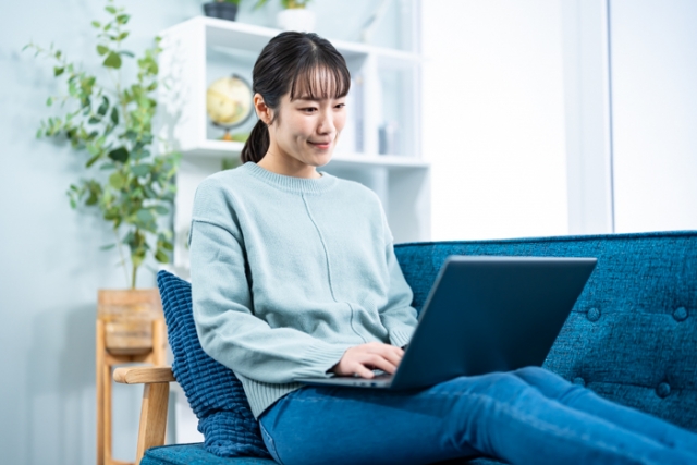 女性が自宅のソファで勉強している様子